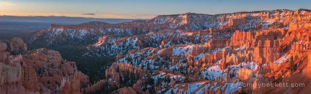 Sunrise at Bryce Amphitheater with warm glow on the hoodoos and snow dotting the canyon walls, Bryce Canyon National Park.