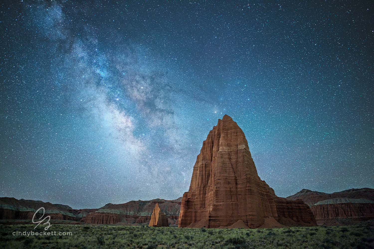 The Milky Way rises above the iconic monoliths, Temple of the Sun and Temple of the Moon, in Capitol Reef National Park, Utah.
